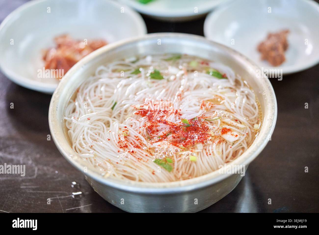 Janchi-guksu sert des nouilles chaudes dans un bouillon salé, contrastant avec le bibim-guksu doux, épicé et froid. Les deux offrent des saveurs coréennes authentiques. Banque D'Images