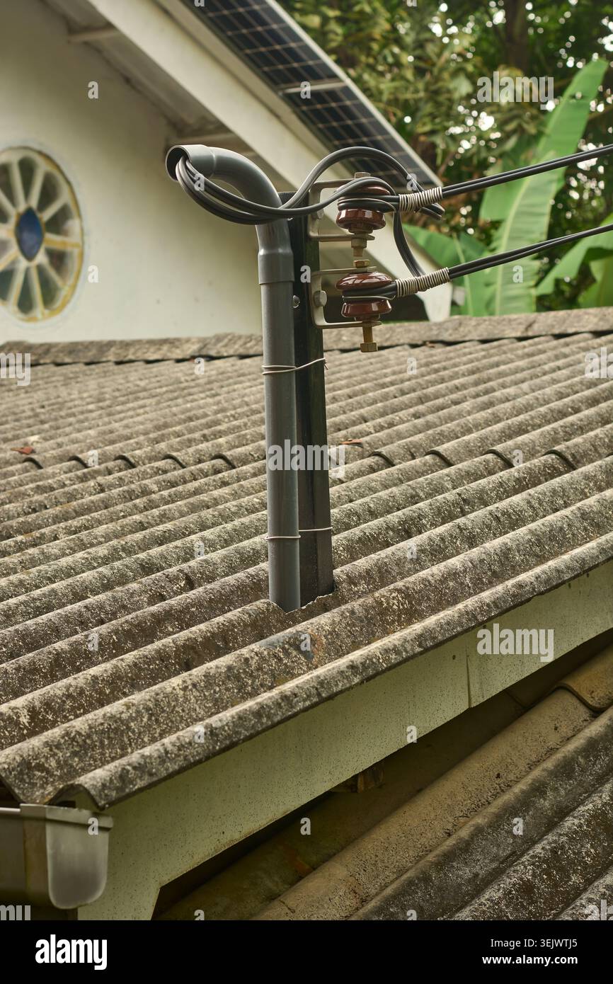 mât électrique d'énergie solaire sur toit ondulé, isolants et fils noirs sur fond de toit, soft focus gros plan et espace de copie, énergie renouvelable Banque D'Images