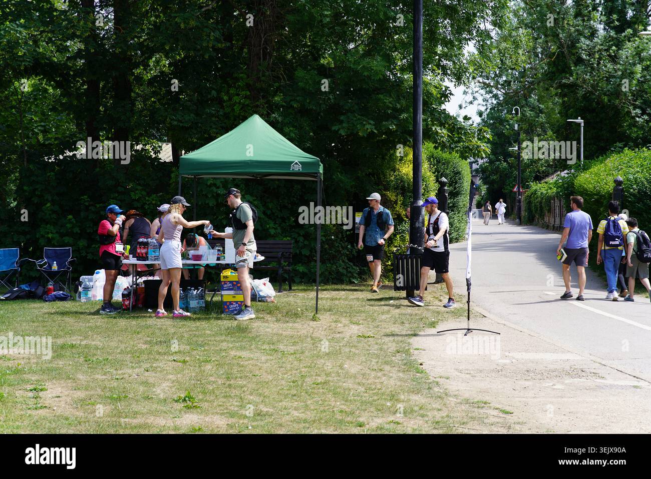 Tente de station d'aide verte avec des bénévoles et des coureurs à la course de course à pied de Tonbridge le jour ensoleillé dans le cadre du parc. Banque D'Images
