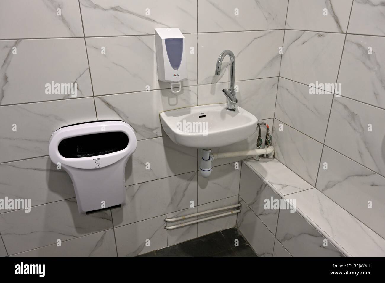 Lavabo, distributeur de savon et sèche-mains dans les toilettes publiques Banque D'Images