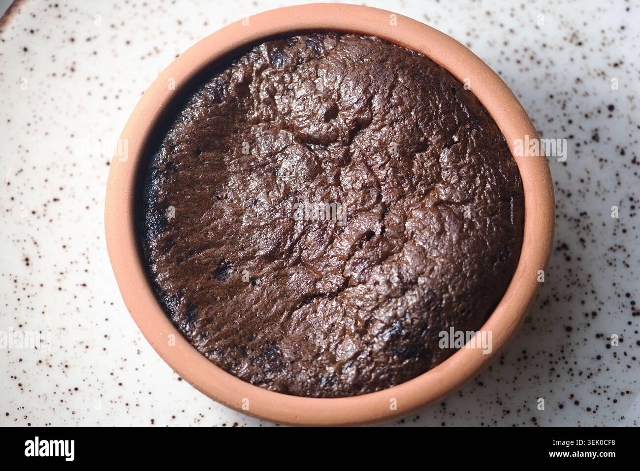 Gâteau au chocolat noir dans un pot en argile sur une assiette Banque D'Images