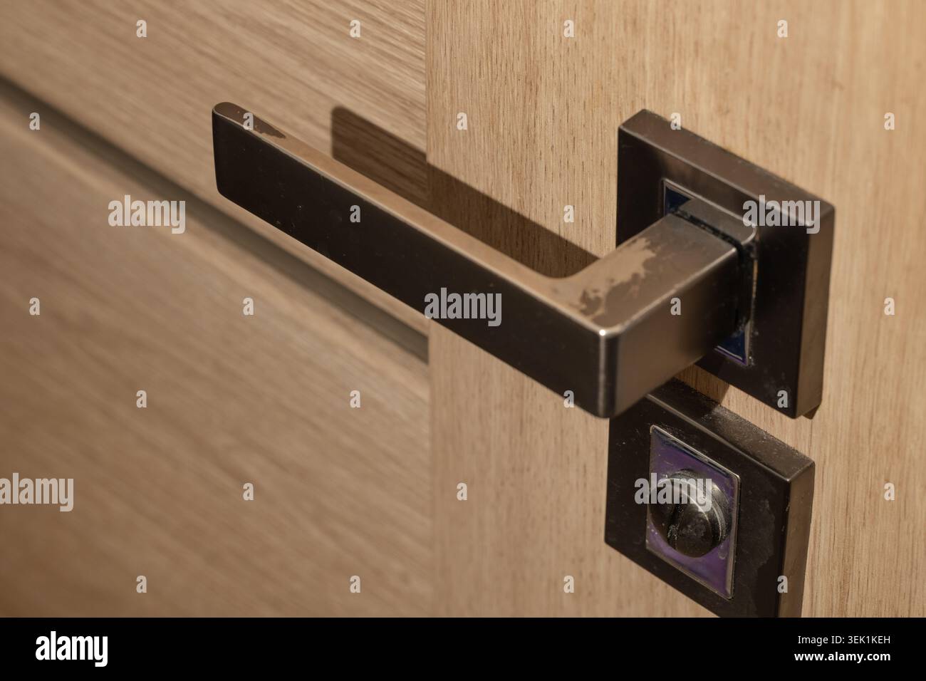 Poignée de porte en métal foncé sur porte en bois Banque D'Images