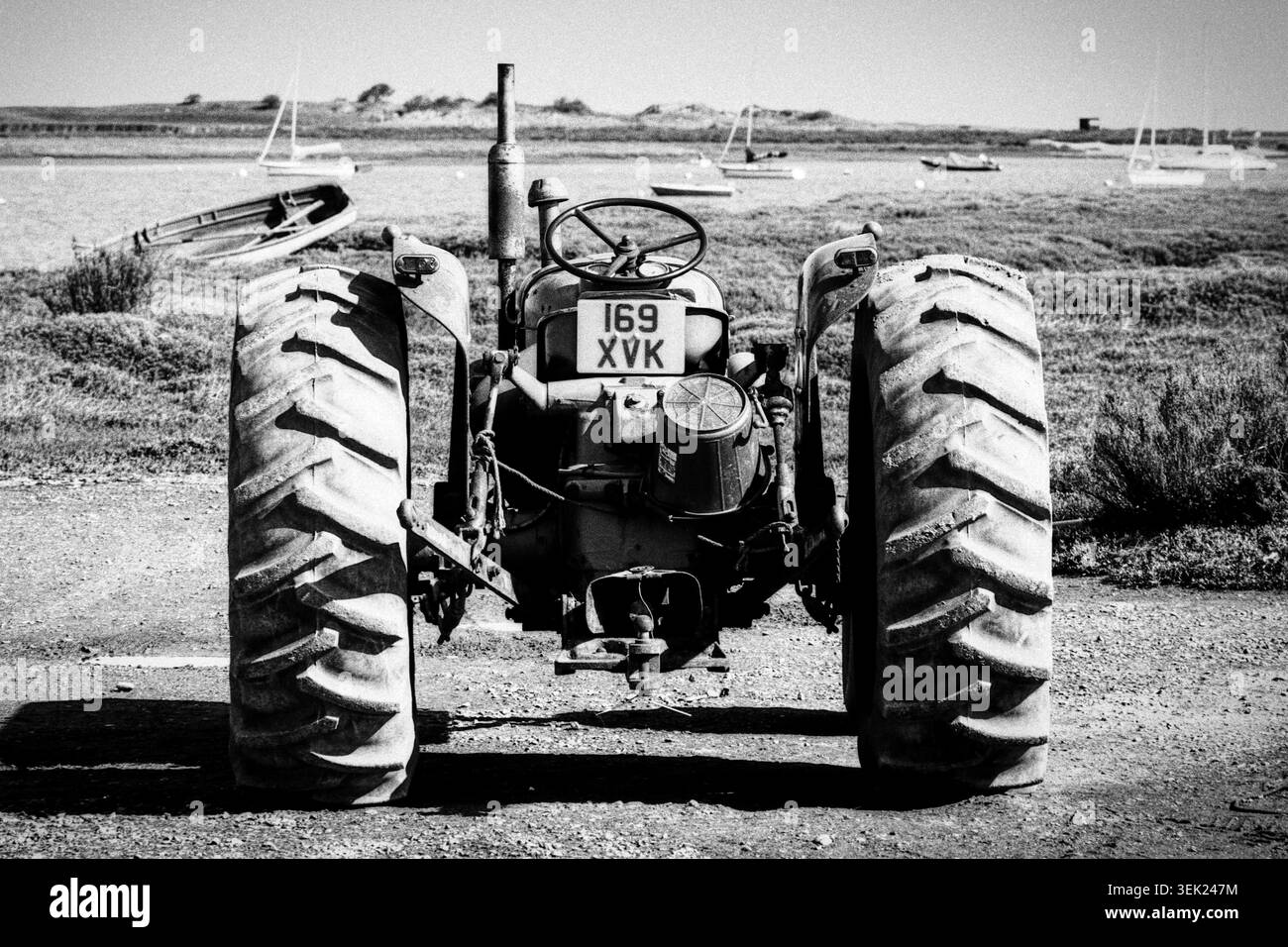 Vieux tracteur utilisé par les pêcheurs à Brancaster Staithe dans le Norfolk tourné sur film mono Banque D'Images