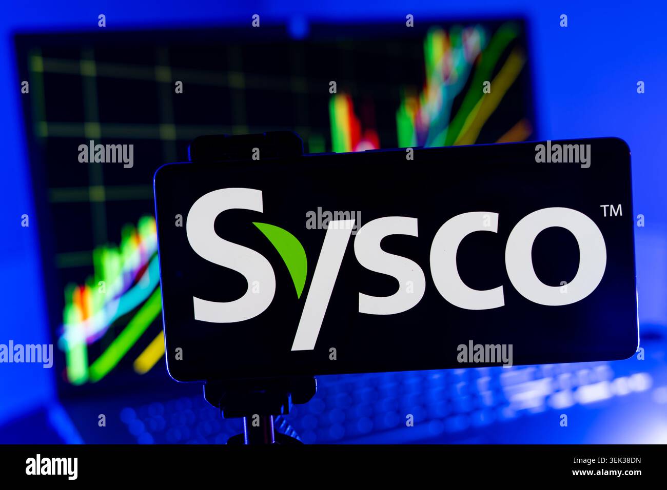 Logo Sysco affiché sur téléphone portable avec fond de graphique de performance boursière et interface graphique de trading Banque D'Images