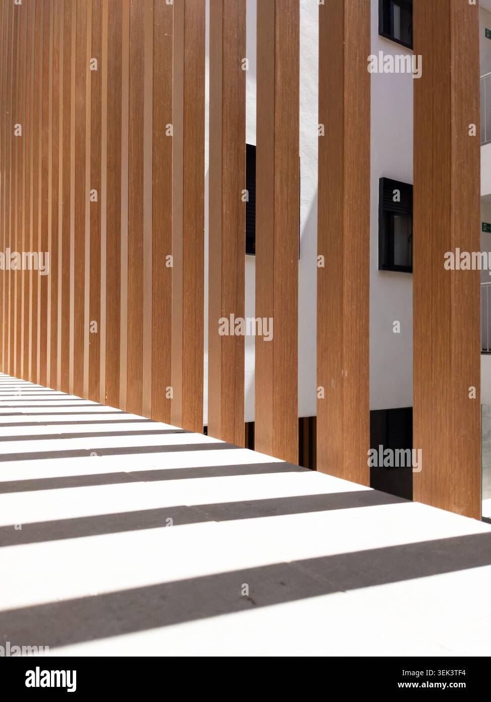 Façade architecturale moderne avec lattes en bois et motif d'ombre géométrique Banque D'Images
