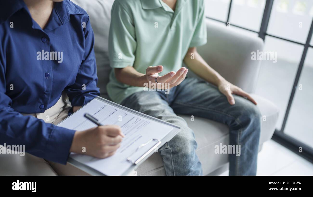 Homme triste assis sur le canapé patient discute de problèmes de santé mentale avec un psychologue. Concept de traitement asiatique dépressif des problèmes de santé mentale Banque D'Images
