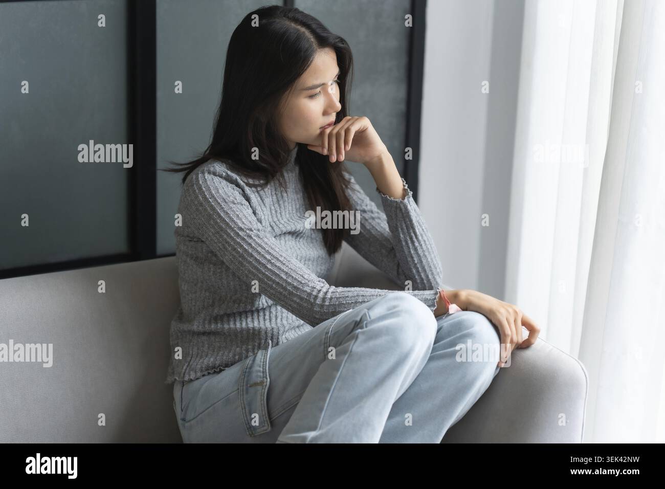 Jeune femme asiatique se sent seule, triste, malade, stressée, seule à la maison sur le canapé pour profiter du mode de vie de bien-être dans les soins de santé Banque D'Images