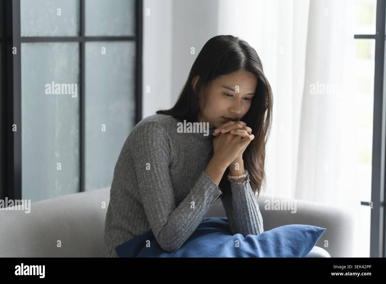 Jeune femme asiatique se sent seule, triste, malade, stressée, seule à la maison sur le canapé pour profiter du mode de vie de bien-être dans les soins de santé Banque D'Images