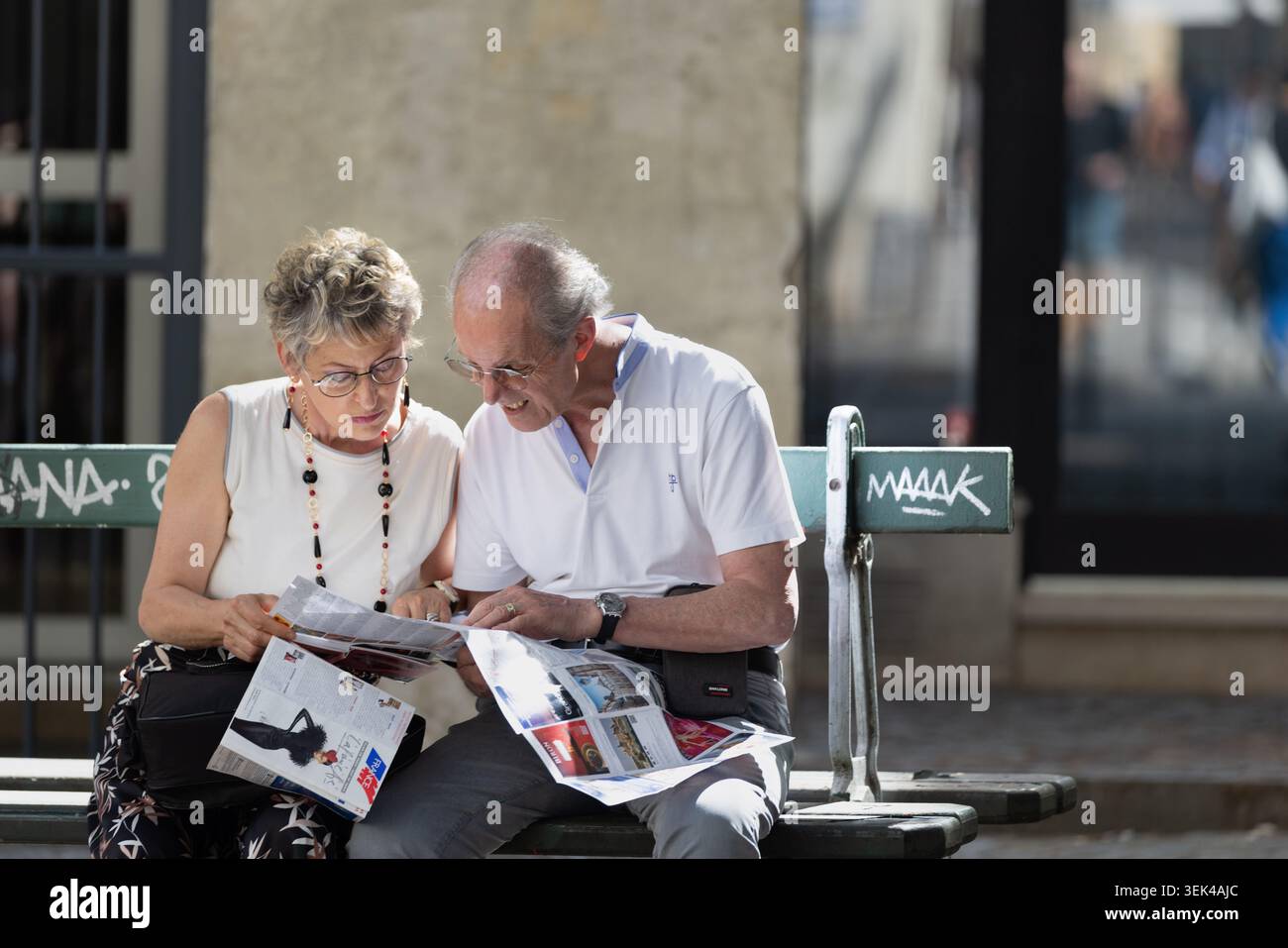 Couple lisant une carte touristique sur un banc à Paris, France. Banque D'Images