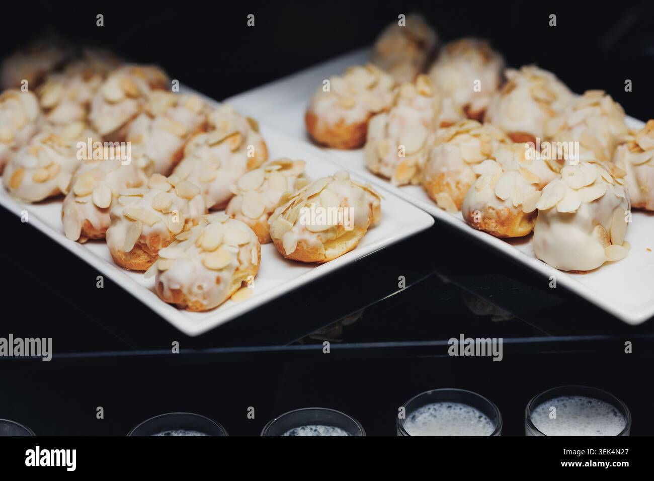 Les pâtisseries enrobées d'amandes brillent sur les assiettes blanches Banque D'Images