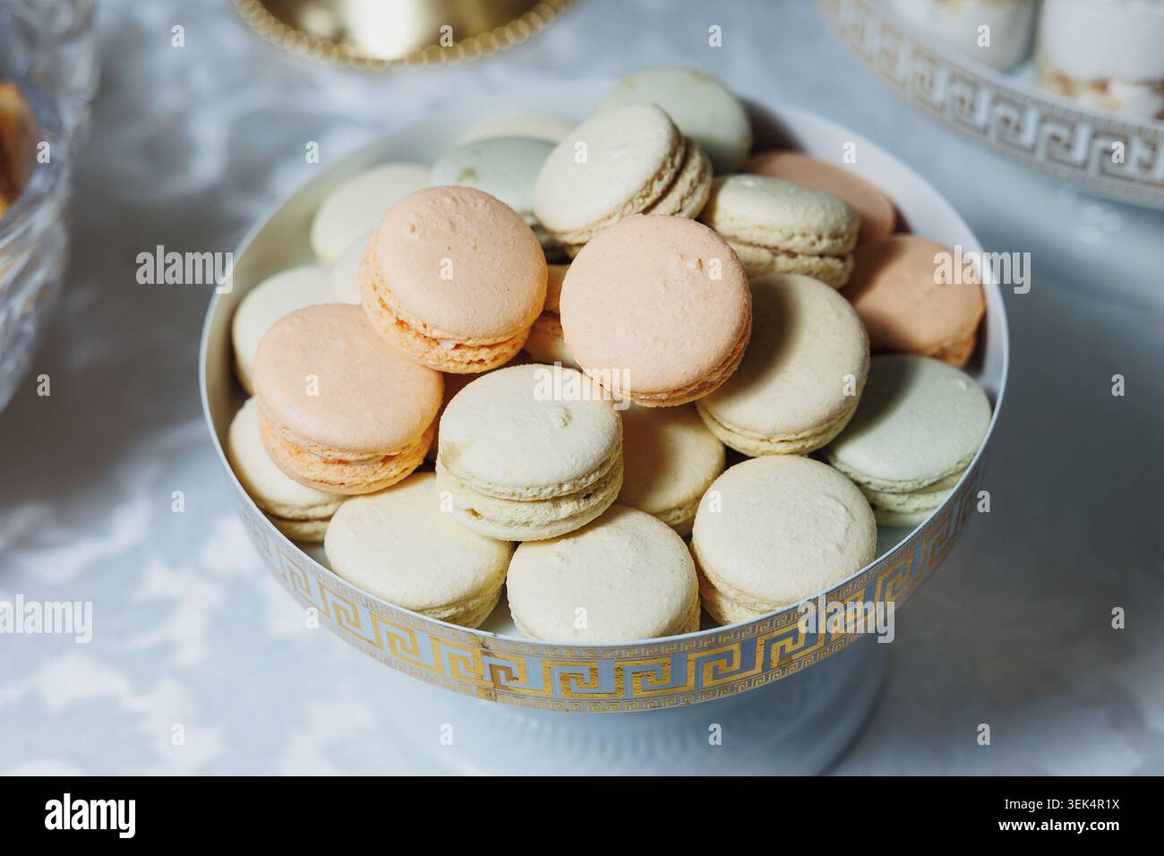 Macarons pastel nichés dans un élégant bol à motifs Banque D'Images