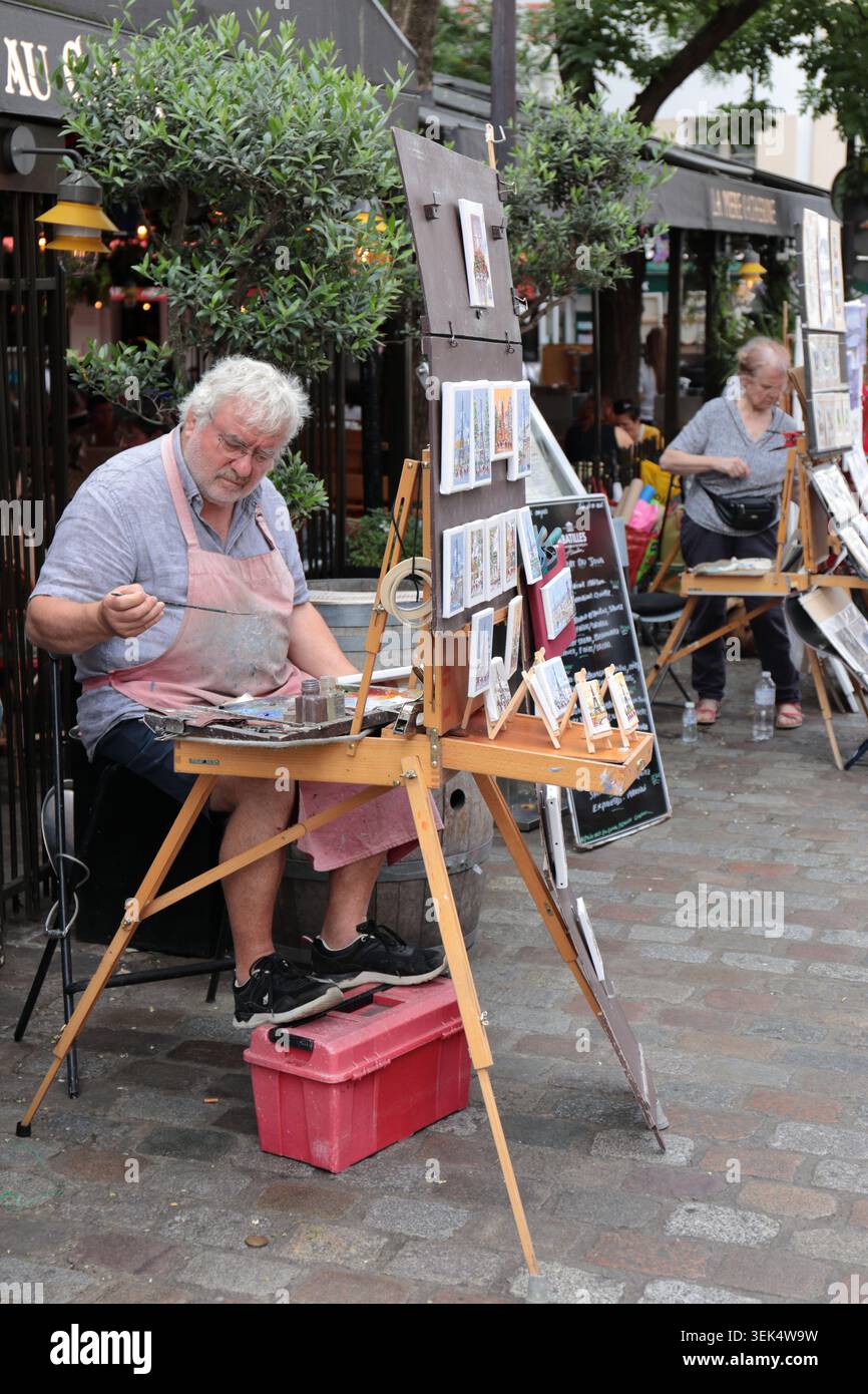 Paris, France - 9 août 2024 : artiste de rue traditionnel travaillant sur des aquarelles et offrant des œuvres d'art originales faites à la main dans un Paris m en plein air Banque D'Images