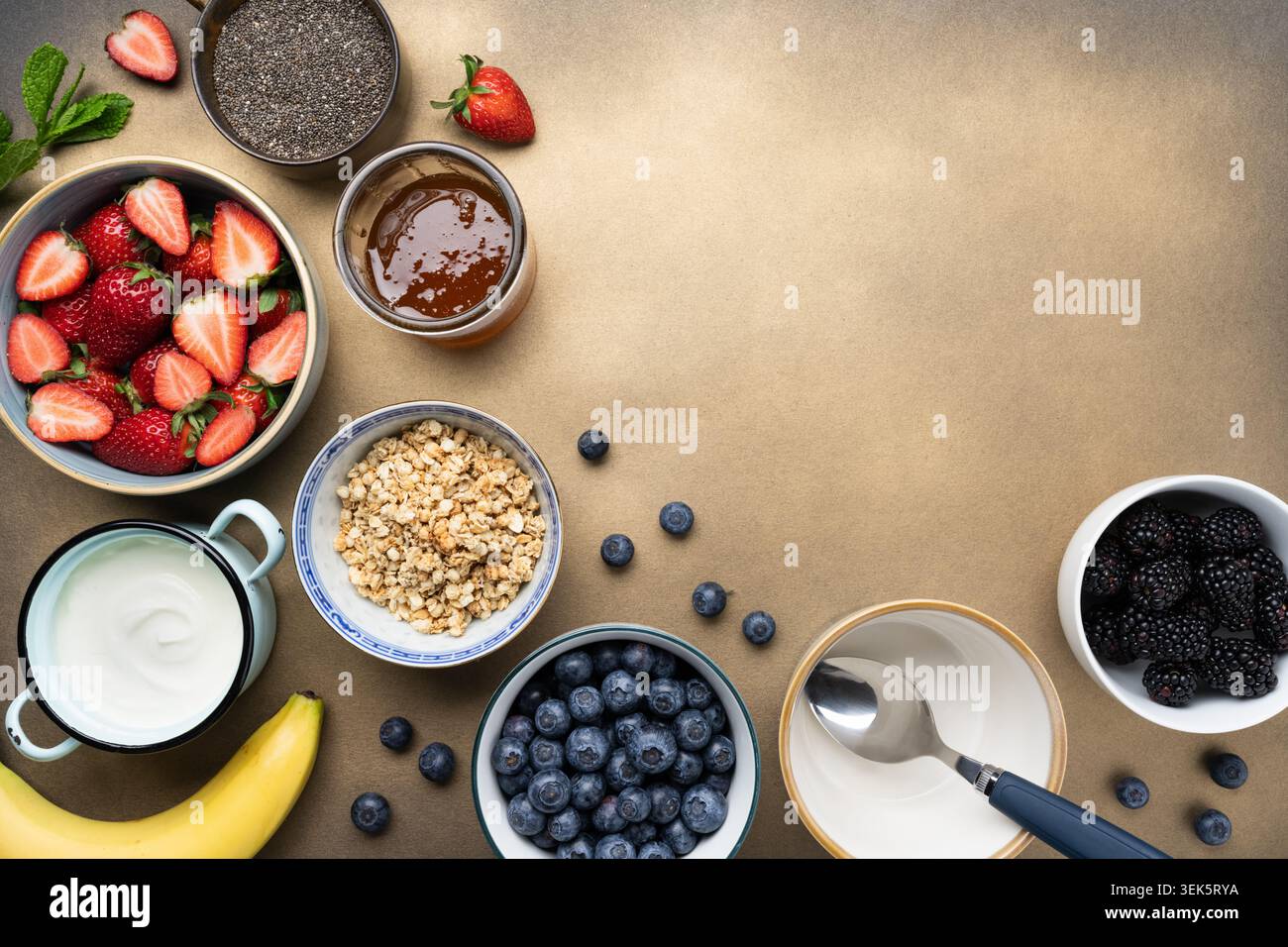 Ingrédients sains pour le petit déjeuner avec granola de baies de yaourt et miel plat Banque D'Images