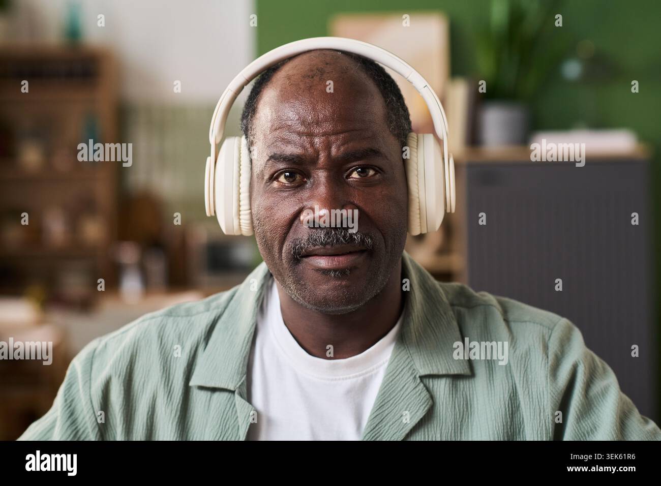 Portrait d'homme senior noir portant des écouteurs pour l'apprentissage en ligne Banque D'Images