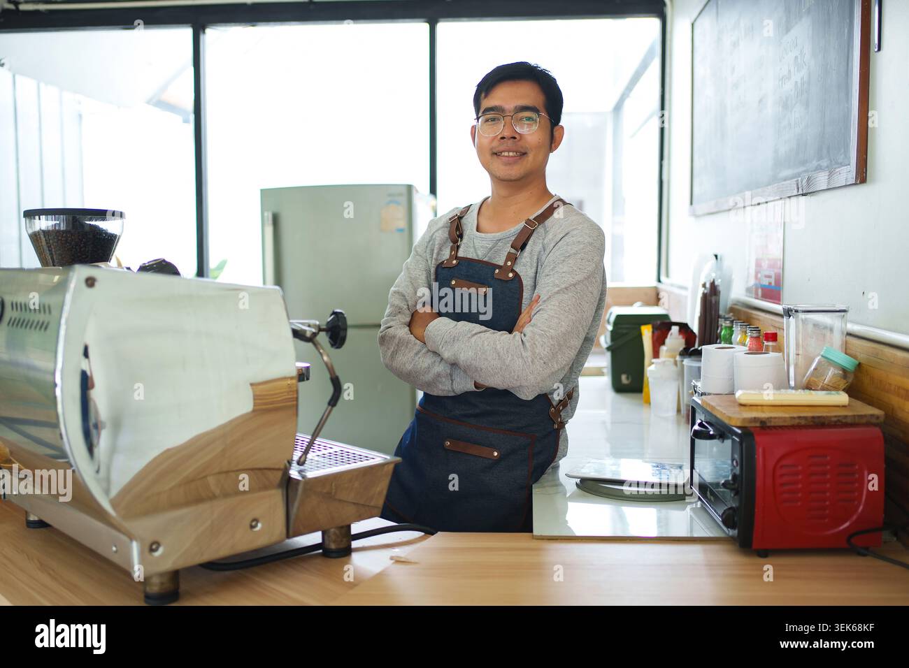 Barista souriant debout dans un atelier de torréfaction de café Banque D'Images