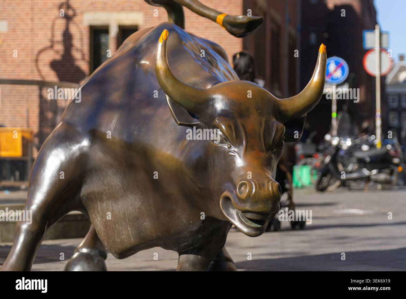 Amsterdam, pays-Bas - 28 avril 2026 : la statue de Charging Bull se dresse devant la Bourse d'Amsterdam parmi les fleurs de tulipes dans le quartier historique. Banque D'Images