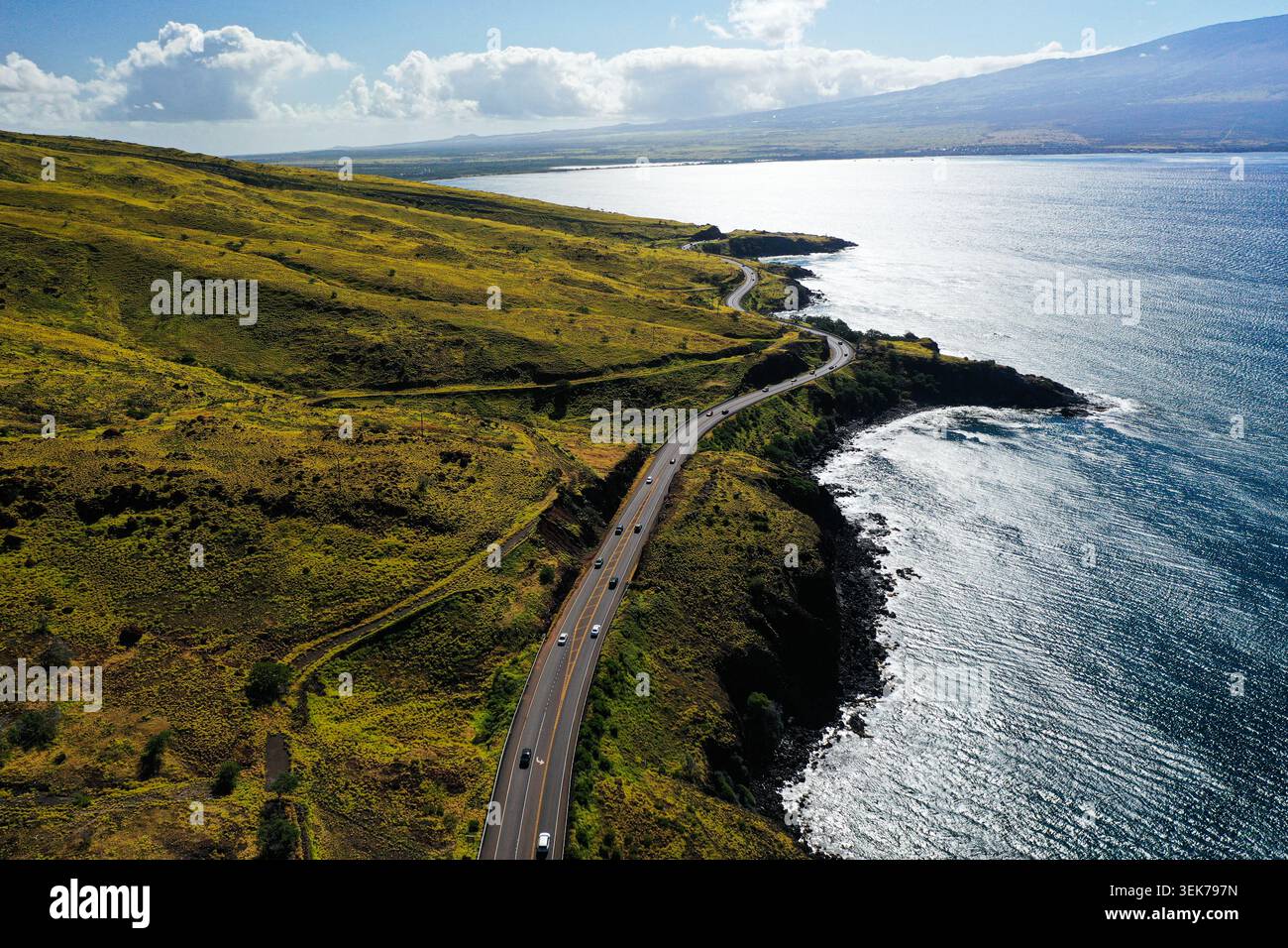 Une vue aérienne époustouflante d'une route côtière sinueuse sur Maui, Hawaï, mettant en valeur des collines verdoyantes, des falaises spectaculaires et l'immense océan Pacifique Banque D'Images