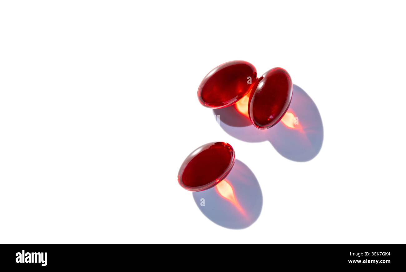 Capsules rouges sur fond blanc - concept minimaliste de santé et de bien-être Banque D'Images