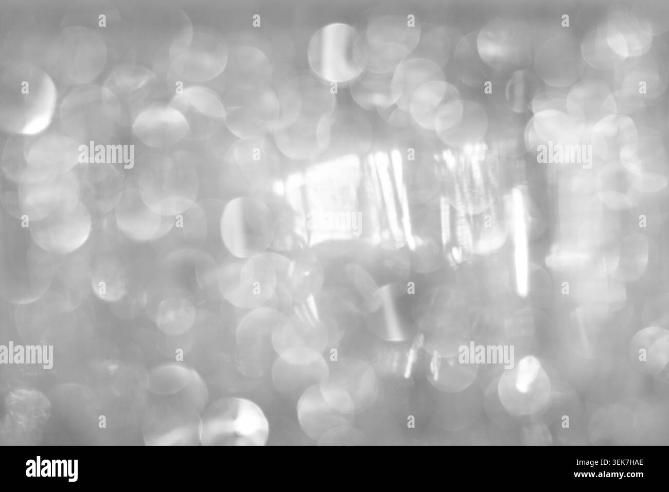 Fond abstrait argenté Bokeh avec des cercles de lumière défocalisée pour des visuels élégants Banque D'Images