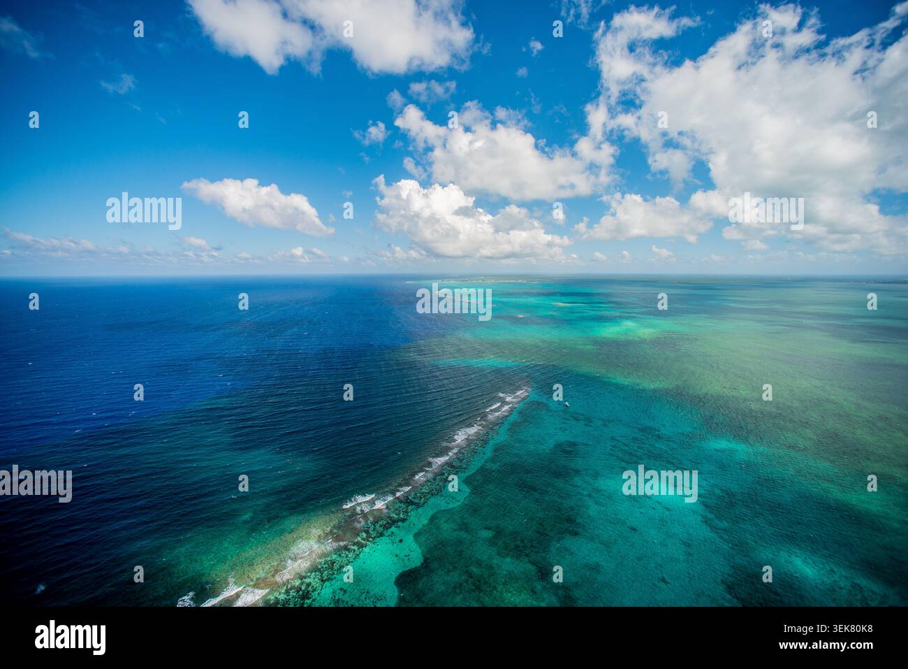 Une photographie aérienne grand-angle capturant la vaste étendue de la mer des Caraïbes bleu profond au large de Grand Caïman, mettant en valeur les eaux turquoises vibrantes Banque D'Images