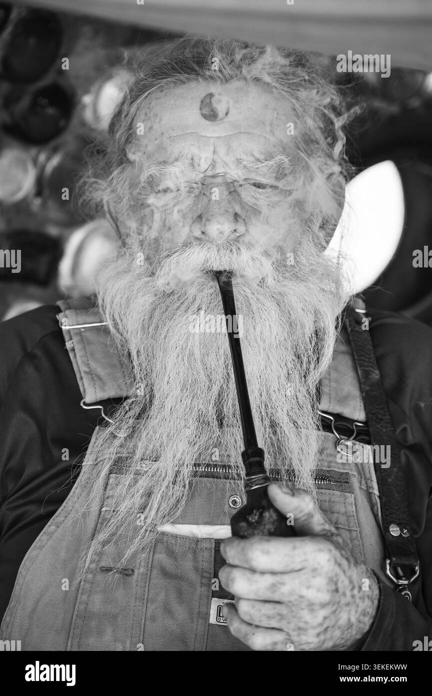 Un résident et artiste de longue date, connu uniquement sous le nom de Magicien, fume sa pipe. Jésus est dans la communauté informelle des artistes de Slab City, près du Salto Banque D'Images