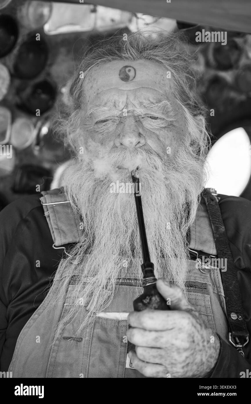 Un résident et artiste de longue date, connu uniquement sous le nom de Magicien, fume sa pipe. Jésus est dans la communauté informelle des artistes de Slab City, près du Salto Banque D'Images