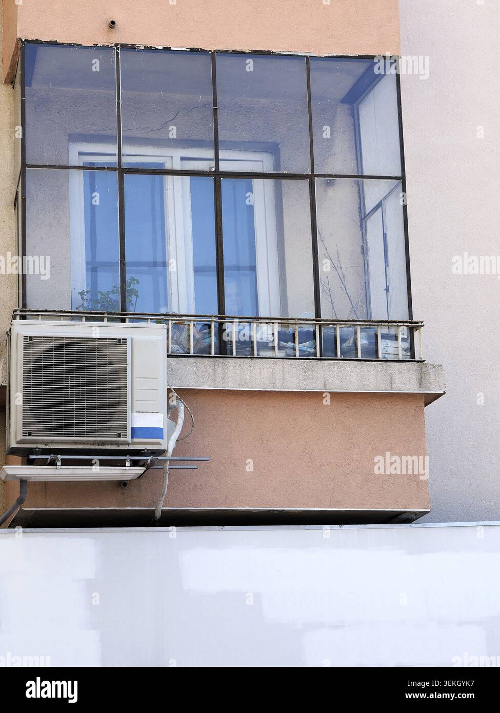 Vue extérieure d'un immeuble résidentiel doté d'un balcon vitré avec une unité de climatisation extérieure montée sur le mur ci-dessous, highlighti Banque D'Images