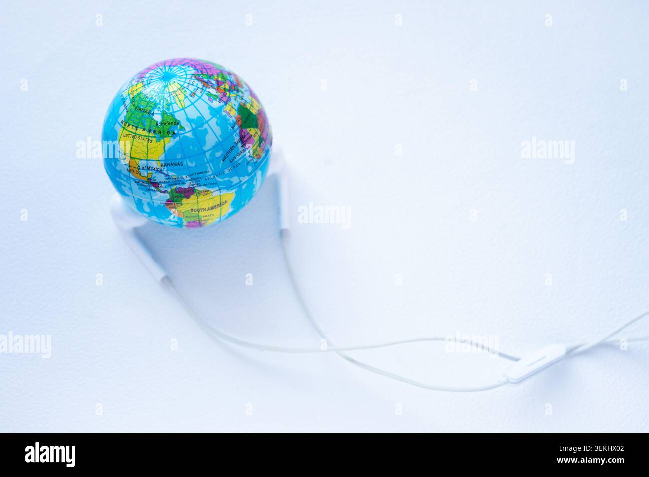 Un globe entouré d'écouteurs, symbolisant la communication mondiale et l'apprentissage à distance Banque D'Images