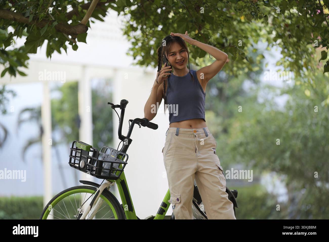 Heureuse jeune femme asiatique monter à vélo dans le parc, ville de rue son sourire en utilisant le vélo de transport, ECO friendly, concept de style de vie écologique des gens Banque D'Images