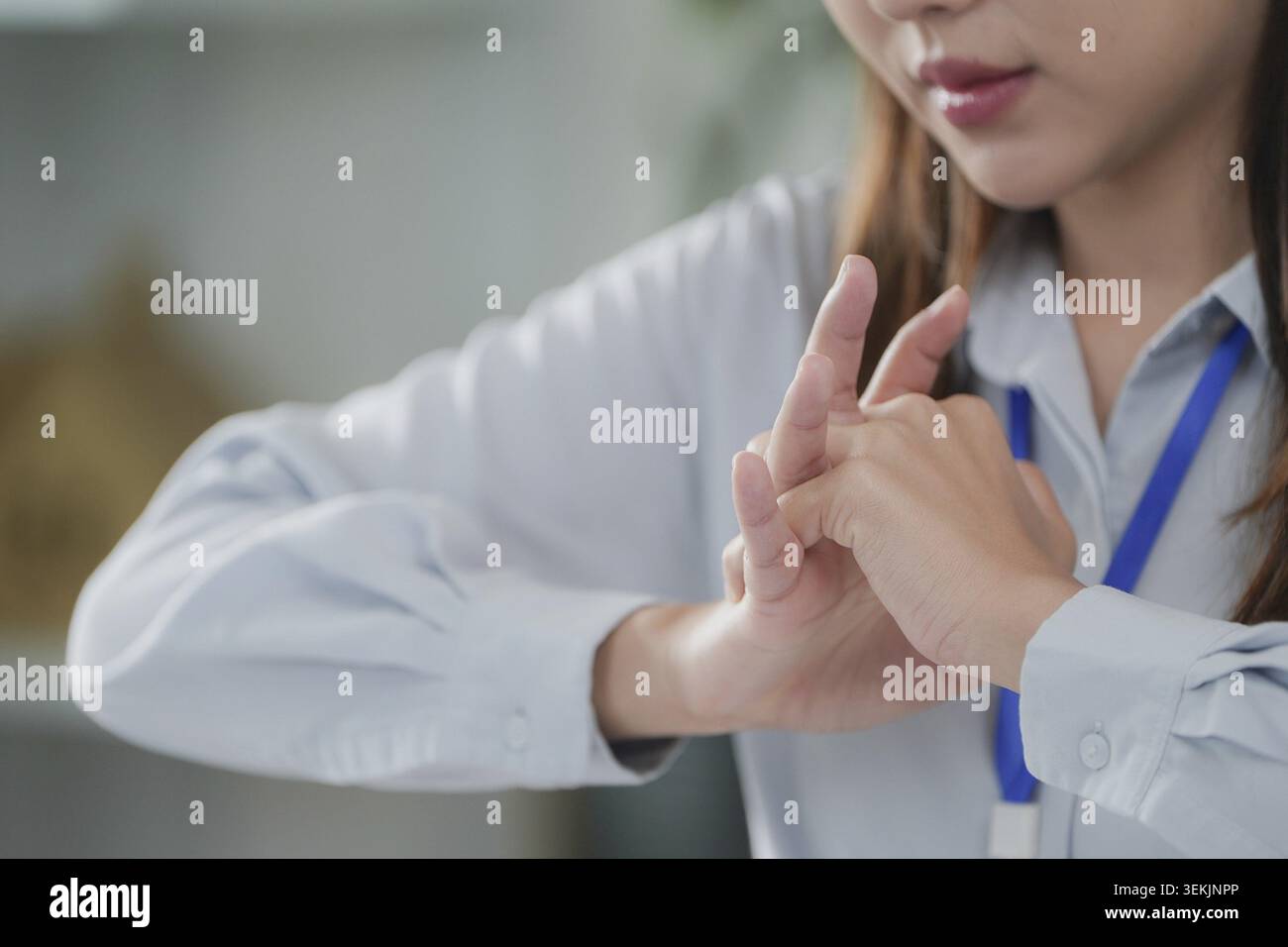Une jeune femme étire les doigts à son bureau, illustrant la nécessité de soulager physiquement le syndrome du cabinet Banque D'Images