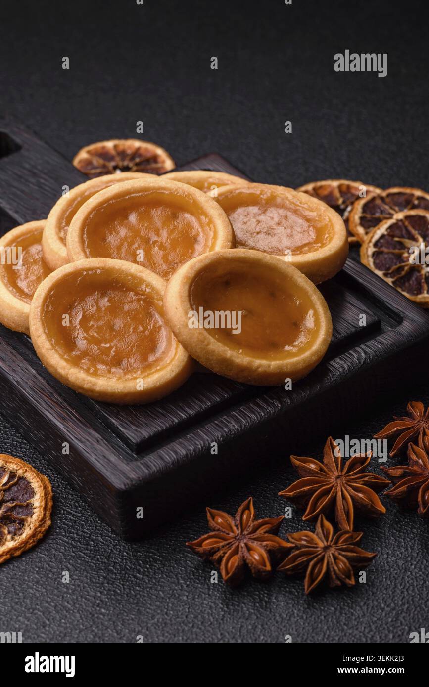 Mini tartelettes rondes avec confiture d'agrumes ou de pêches et pâte friable. Mini tartes aux agrumes comme fond alimentaire pour votre conception Banque D'Images