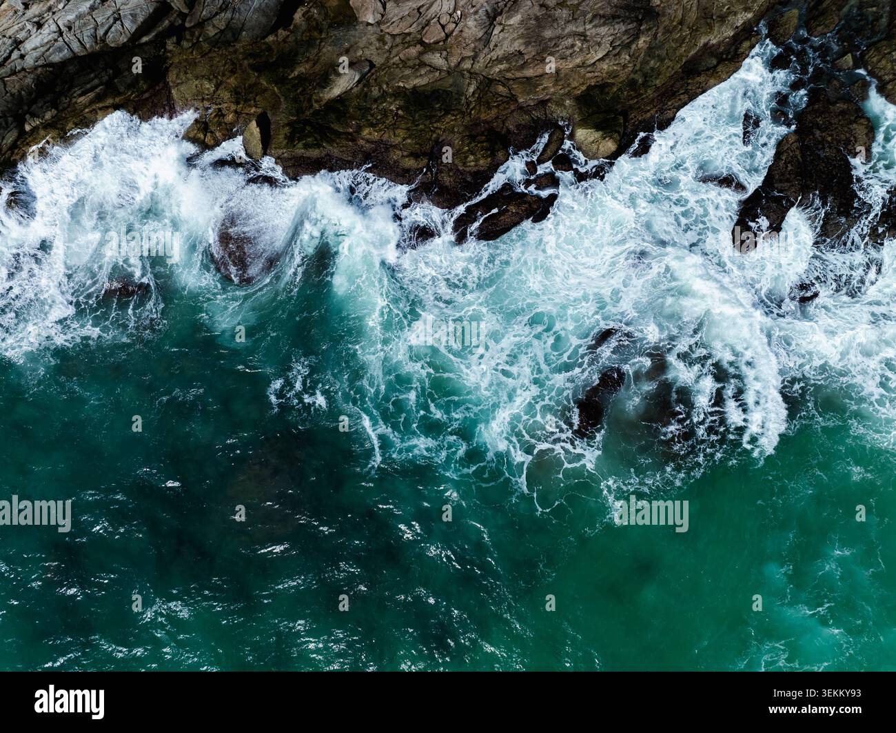 De puissantes vagues de mer s'écrasent contre des formations rocheuses accidentées créant de la mousse et des éclaboussures d'eau dans la mer turquoise d'andaman près de phuket thaïlande. Banque D'Images