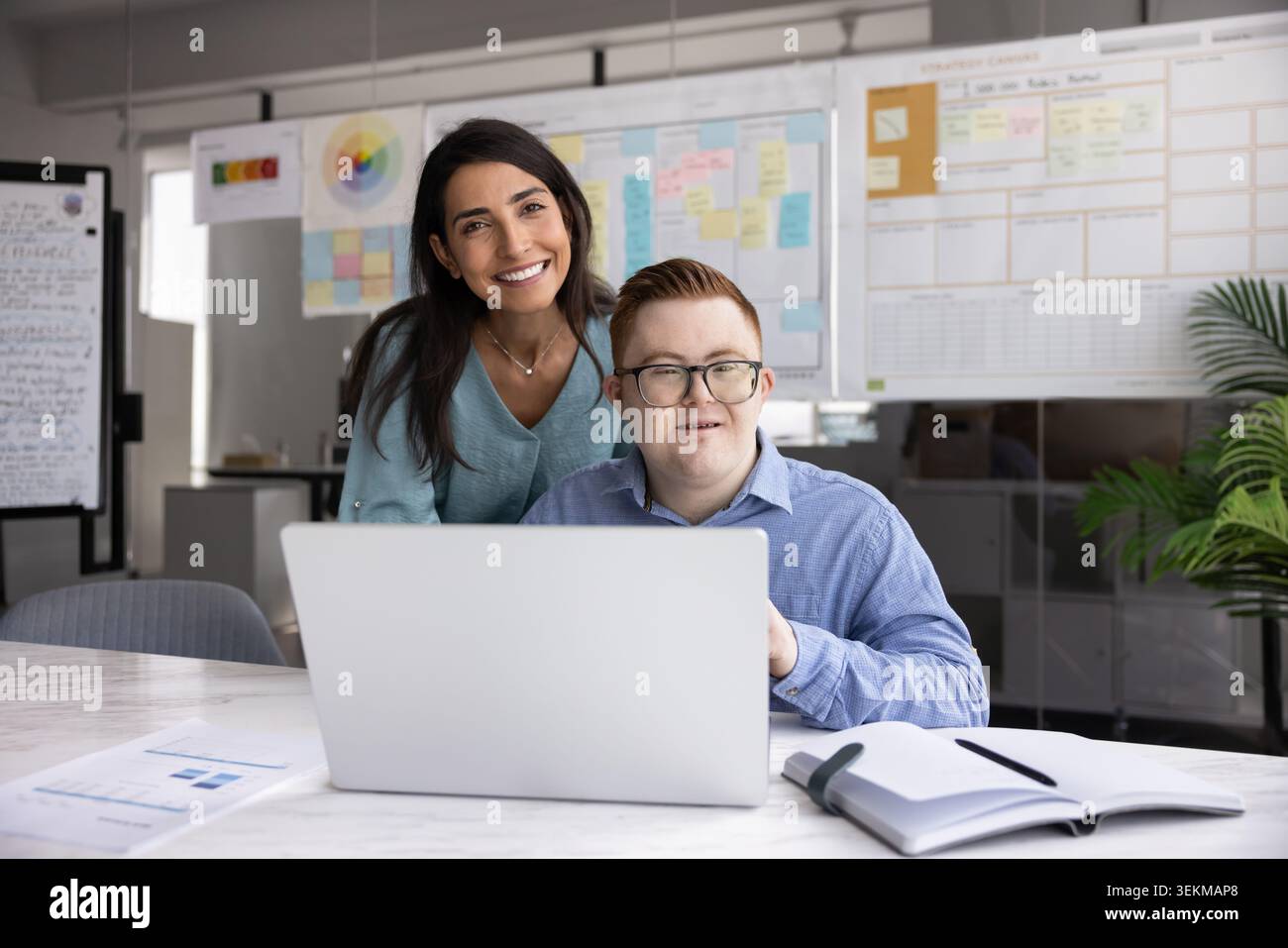 Femme mentor aide avec la tâche à l'homme avec le syndrome de Down Banque D'Images