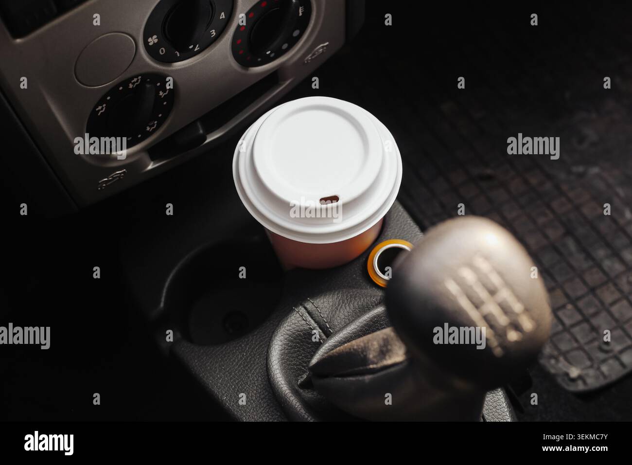 Tasse à café à emporter dans le porte-gobelet de voiture gros plan. Boisson de voyage, style de vie de déplacement et concept de transport à l'intérieur du véhicule. Banque D'Images