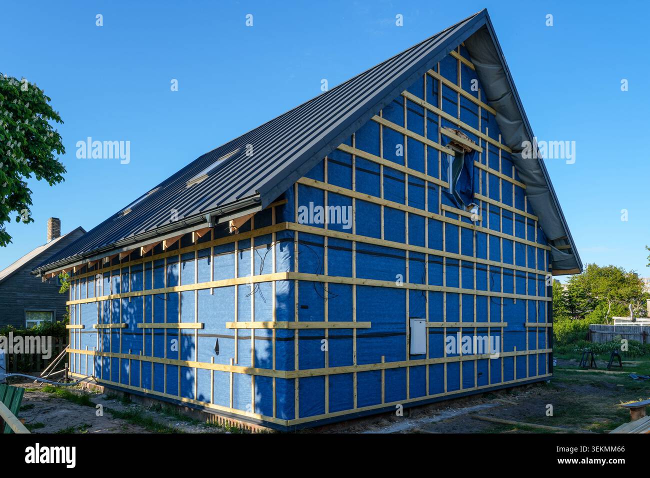 Façade de maison en rénovation avec membrane pare-vent et lattes en bois pour le revêtement extérieur Banque D'Images