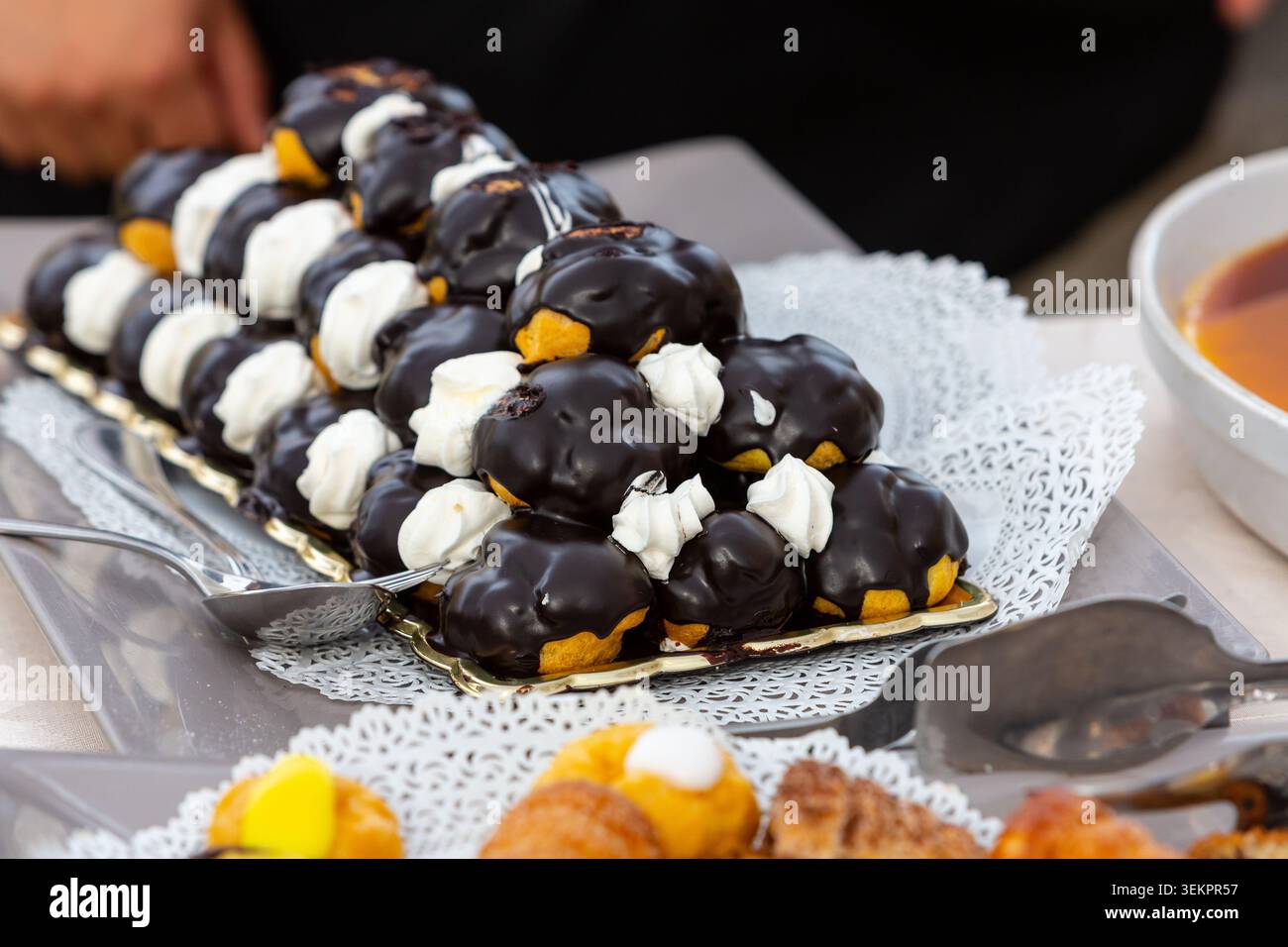 Profiteroles au chocolat et pâtisseries présentées sur un plateau de service pour un événement traiteur Banque D'Images