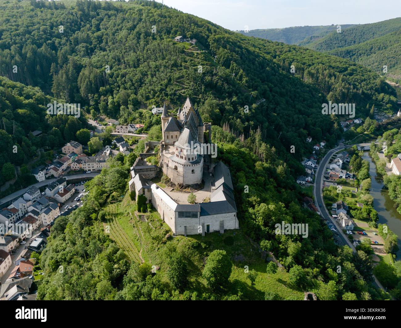 Vue aérienne du château de Vianden avec ses fortifications médiévales et ses tours nichées parmi les forêts verdoyantes denses et les collines des Ardennes, Vianden, VI Banque D'Images