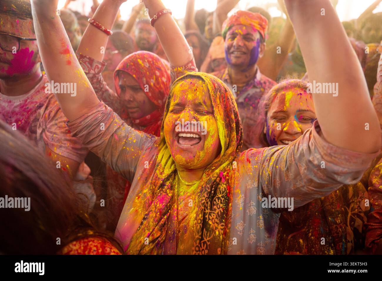 Des fêtards couverts de poudre colorée célébrant Holi, temple Govind Devji, Jaipur, Rajasthan, Inde Banque D'Images