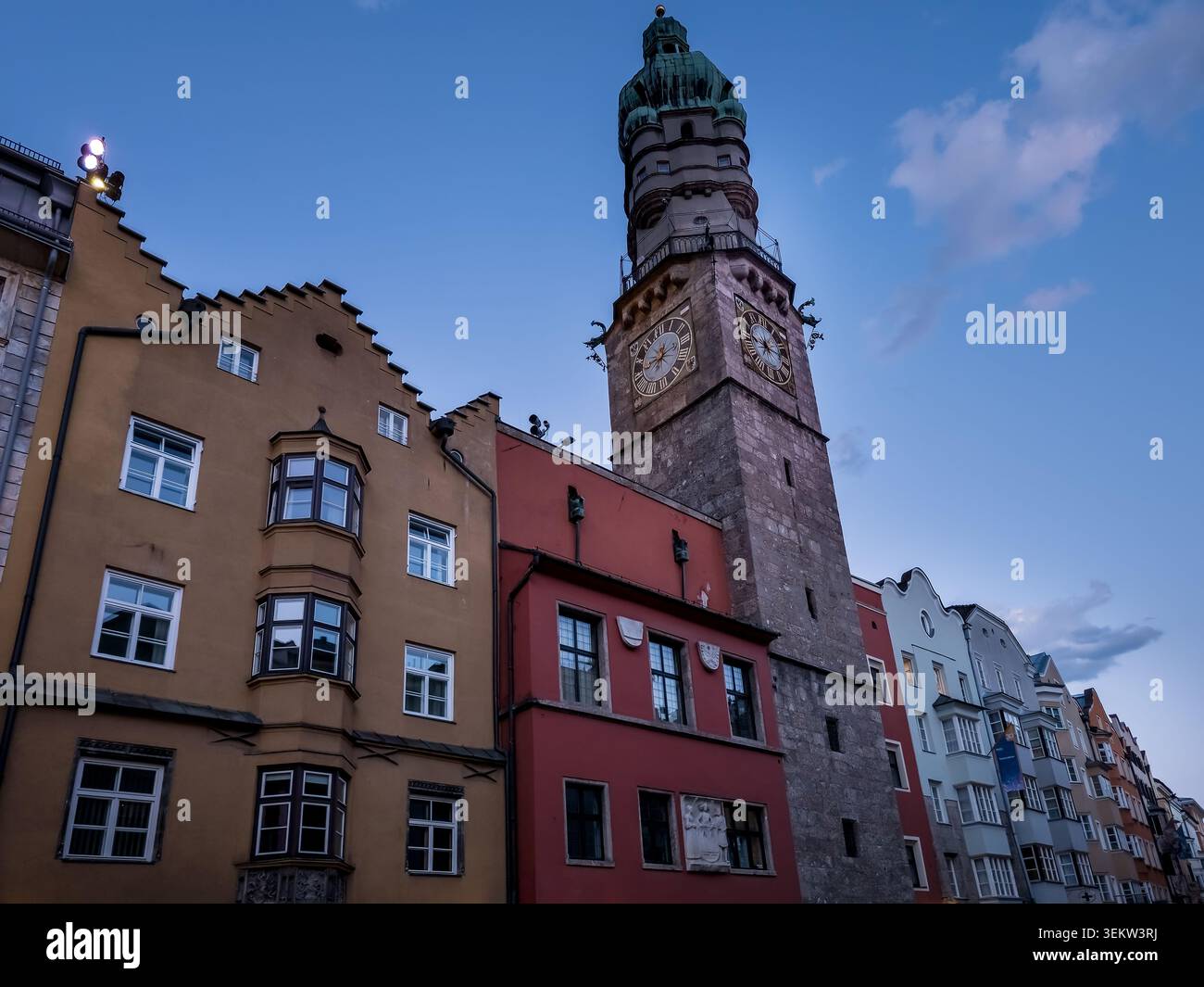 Vue en bas angle sur le Stadtturm - la tour médiévale d'Innsbruck - s'élevant au-dessus des maisons de ville tyroliennes colorées de l'Altstadt (vieille ville) Banque D'Images