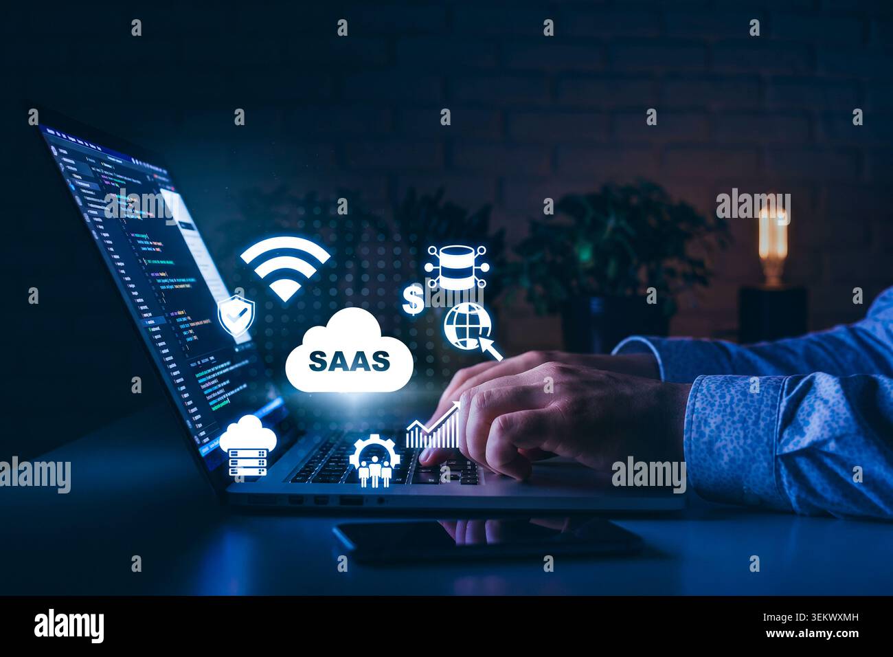 Concept SaaS avec ordinateur portable, icônes de cloud et mains travaillant sur des tâches logicielles la nuit Banque D'Images