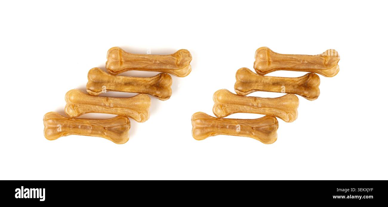 Os en cuir brut isolés, nourriture à mâcher pour chiens au collagène, croquettes sèches pressées, gâteries naturelles de soins dentaires canins de longue durée en forme d'os sur fond blanc Banque D'Images