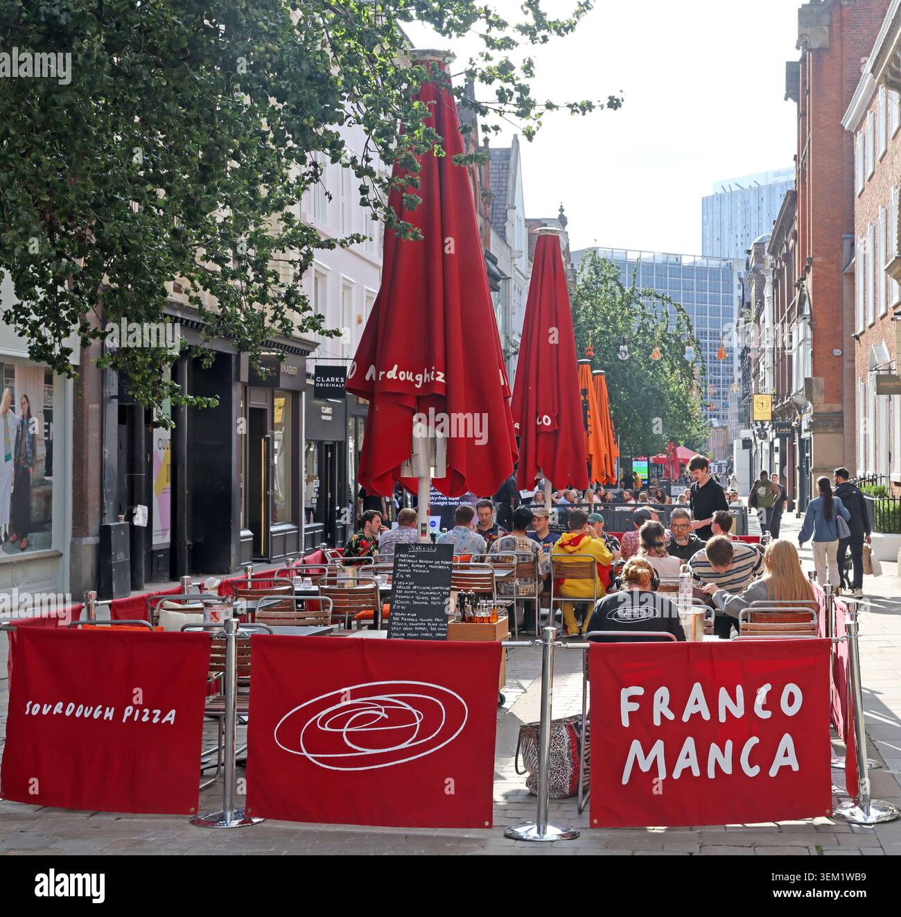 Restaurant Franco Manca au 37 King Street dans le centre-ville de Manchester, Angleterre, Royaume-Uni, avec des tables extérieures et des parasols rouges. Banque D'Images
