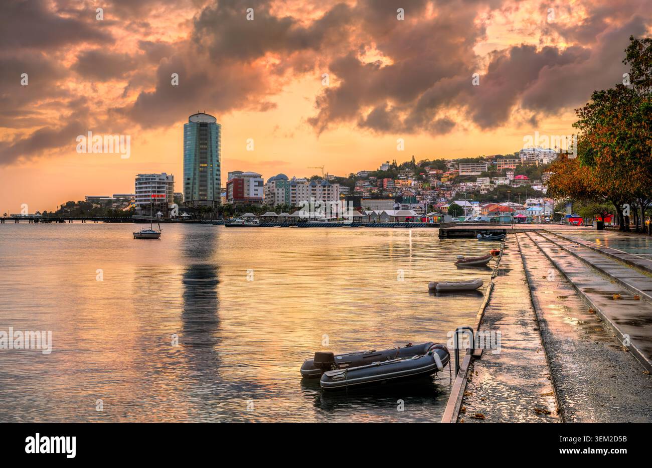 Coucher de soleil heure d'or reflétant sur l'eau calme de la baie avec des bateaux et l'horizon de la ville à Fort-de-France, Martinique, les Caraïbes petites Antilles Banque D'Images