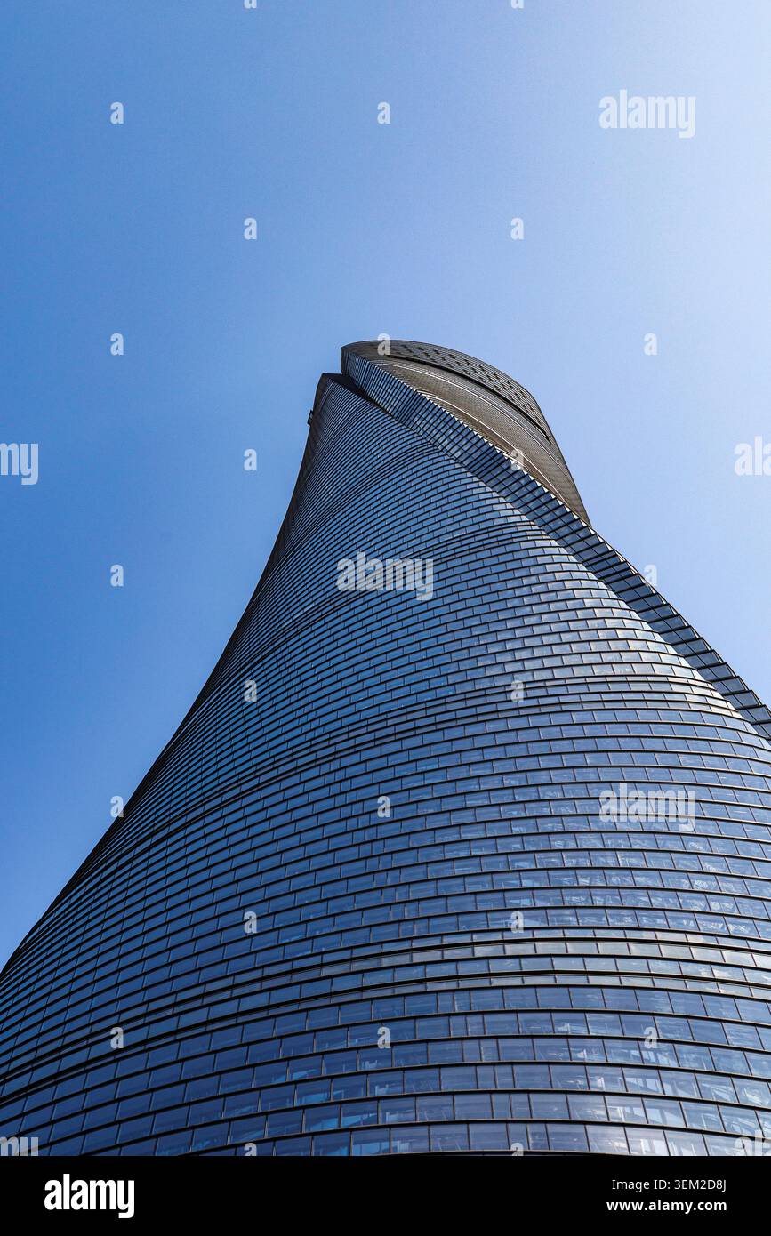 Vue en bas angle de la façade en verre torsadée de la tour de Shanghai qui monte en spirale dans le ciel bleu, Shanghai, Chine Banque D'Images