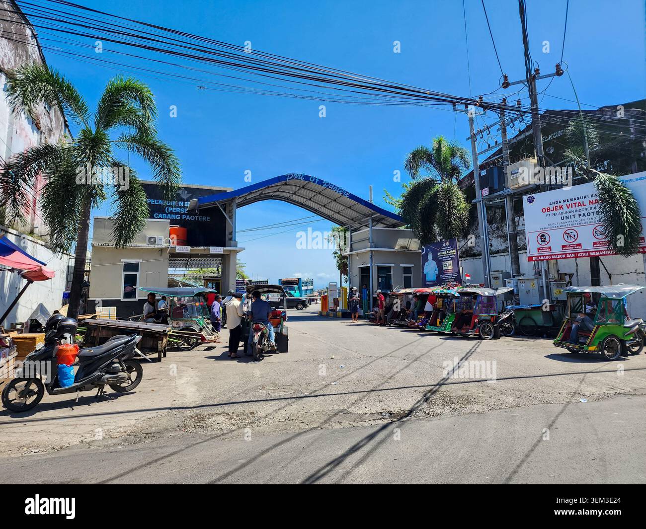 Makassar, Indonésie - 09 février 2024 : Porte d'entrée du port de Paotere avec des tricycles (becak) garés sous un ciel bleu. Banque D'Images