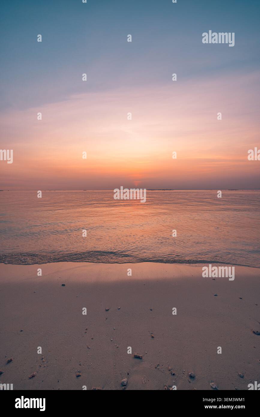 Couchant rose rêveur brillant sur l'océan tropical et la plage tranquille à la douceur dorée du crépuscule. Rivage paisible de paysage estival. Voyage de vacances au paradis, lune de miel, romance Banque D'Images