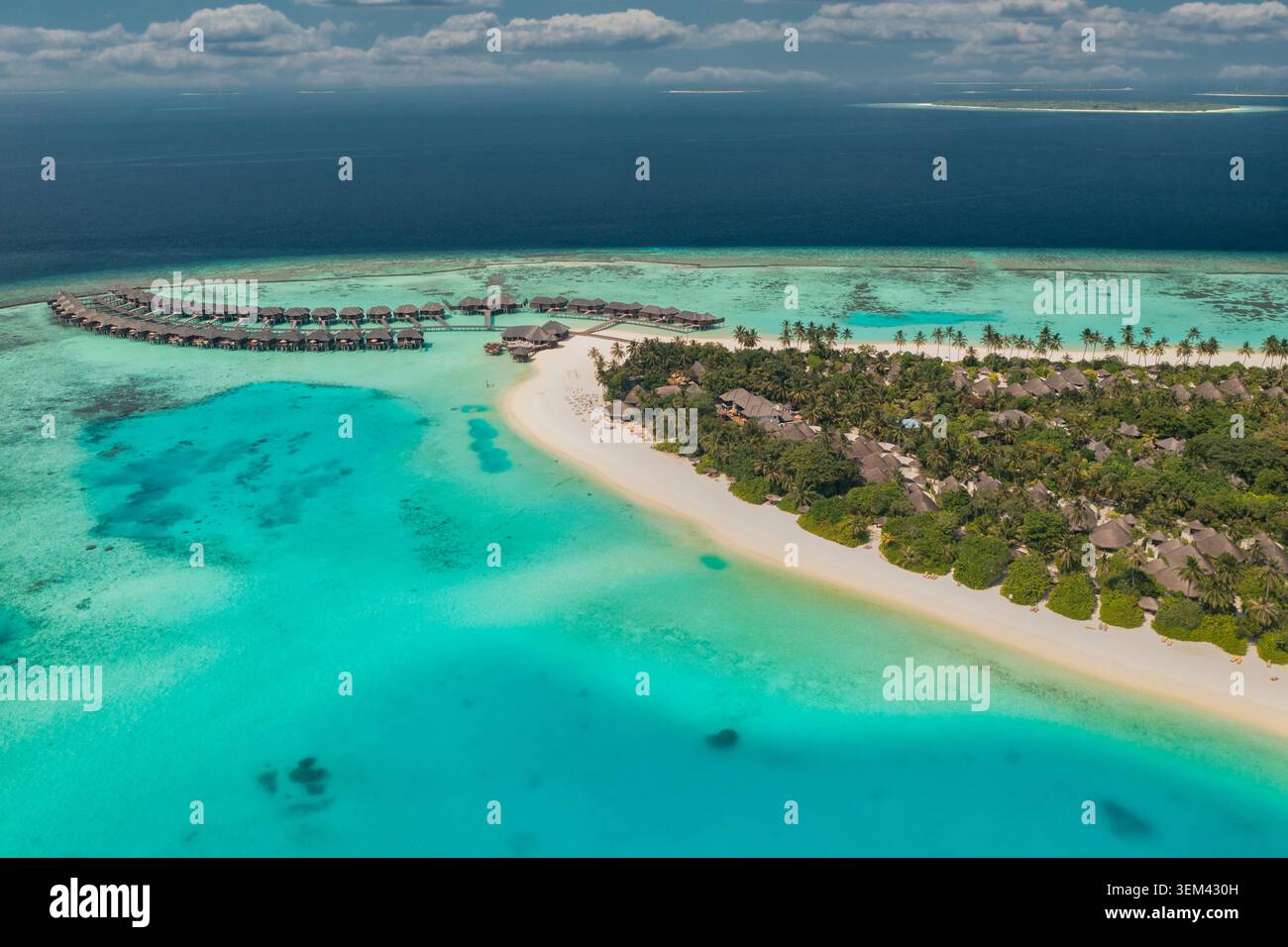 Vue aérienne d'une île de resort tropicale avec des villas sur l'eau, une jetée et un lagon turquoise. Plage de paradis de luxe. Voyage de vacances, lune de miel, art Banque D'Images