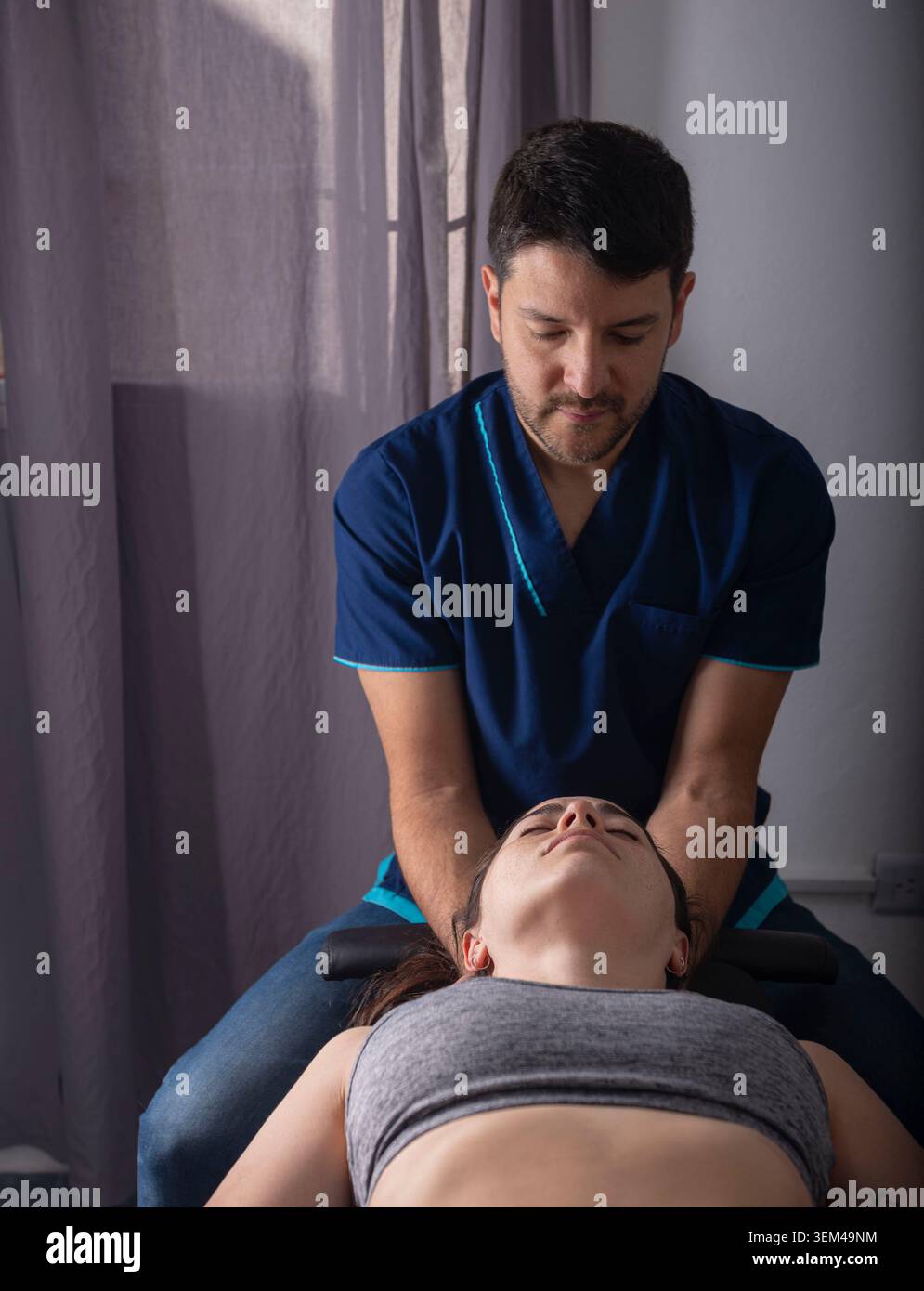 Chiropraticien professionnel effectuant un ajustement cervical Banque D'Images