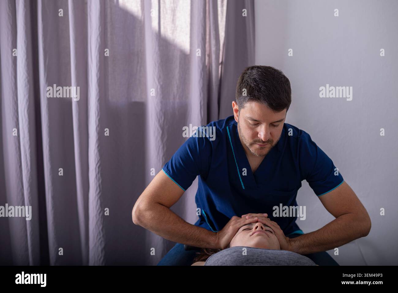 Physiothérapeute appliquant un traitement pratique aux patients Banque D'Images