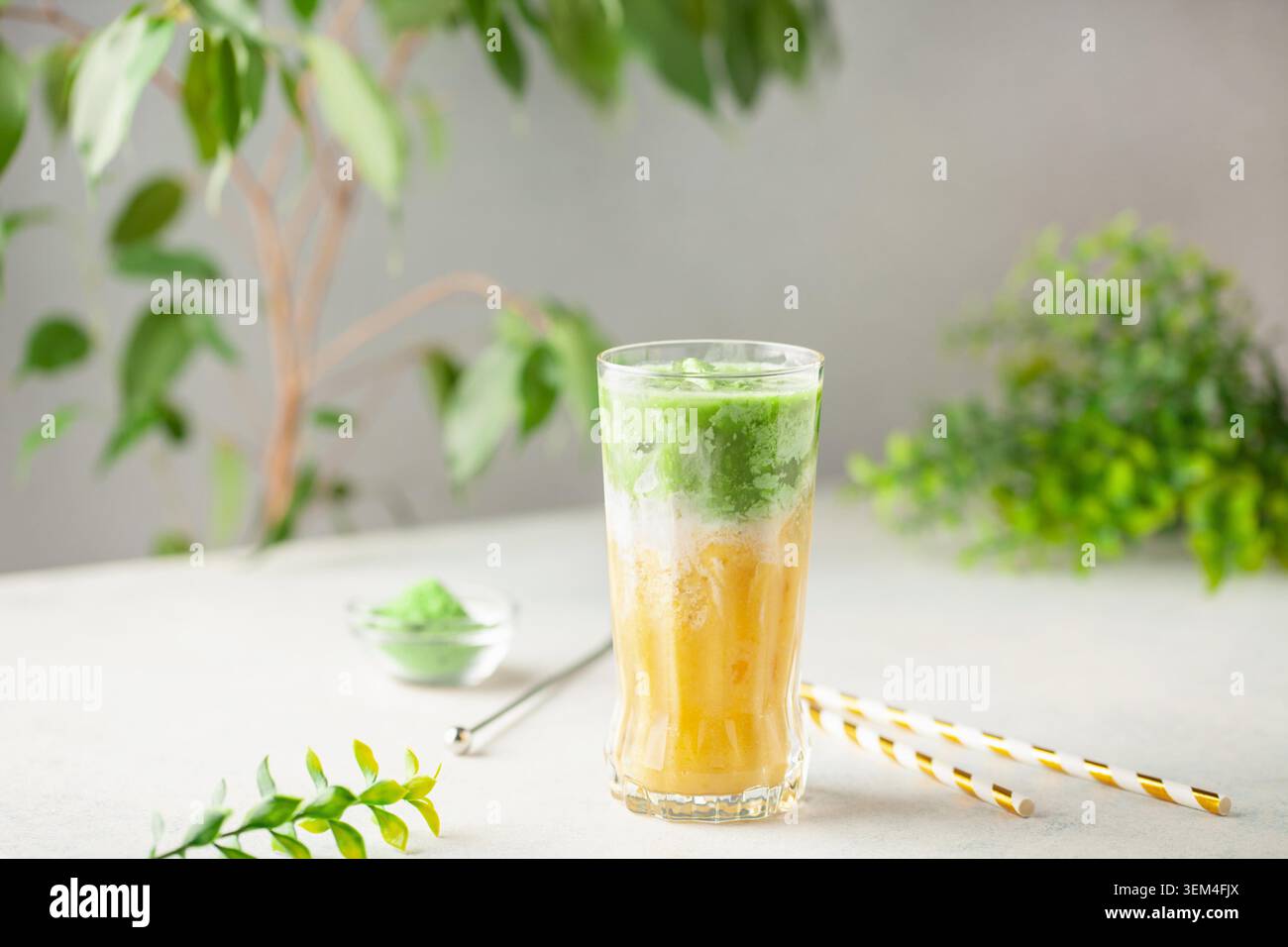 Latte matcha à la mangue glacée en verre sur la table Banque D'Images